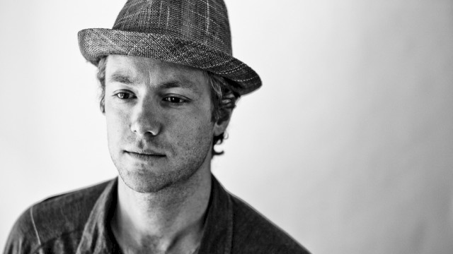 Black-and-white portrait of reggae and funk musician Tone wearing a textured fedora and buttoned shirt, featured live music artist at Currents at Riverhouse in Bend, Oregon.