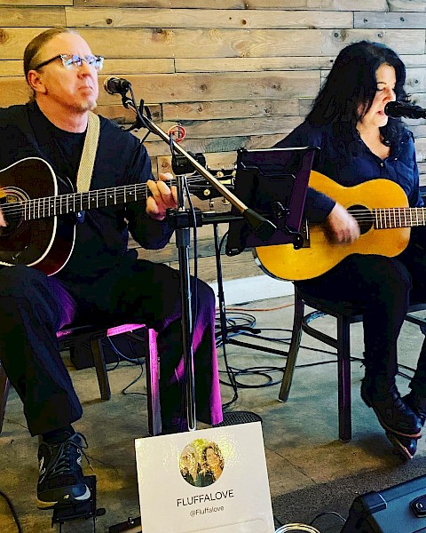 Acoustic duo Fluffalove performs live with guitars and vocal harmonies at Currents at the Riverhouse, a restaurant with live music in Bend, Oregon.