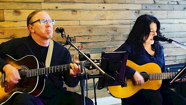 Acoustic duo Fluffalove performs live with guitars and vocal harmonies at Currents at the Riverhouse, a restaurant with live music in Bend, Oregon.